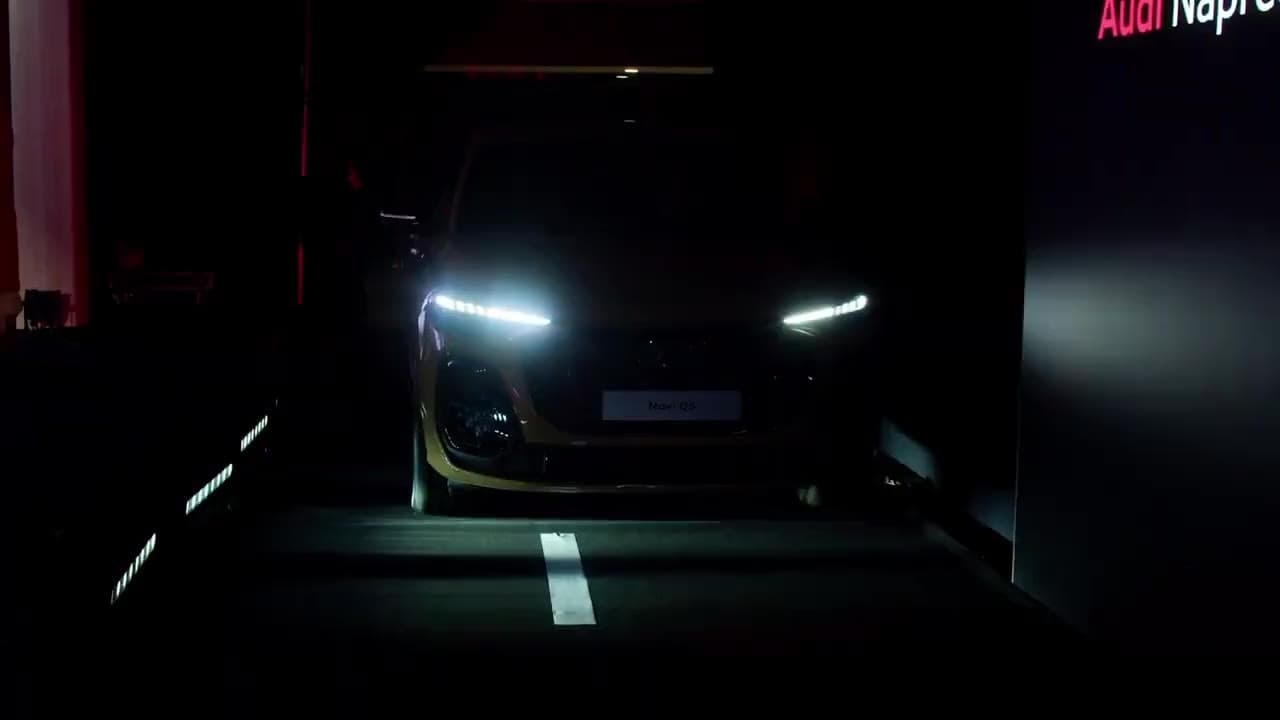 Audi A5 illuminated on a dark stage with red lighting during its launch reveal