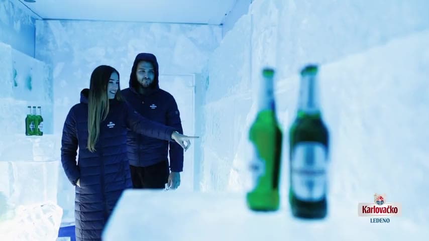 Guests walking through a bar built from carved ice blocks, Karlovačko bottles embedded in the ice walls